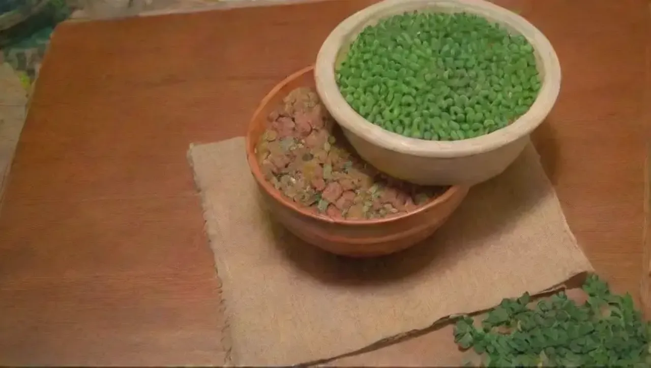 Una mesa de madera llena de legumbres y verduras frescas en un acogedor ambiente de cocina