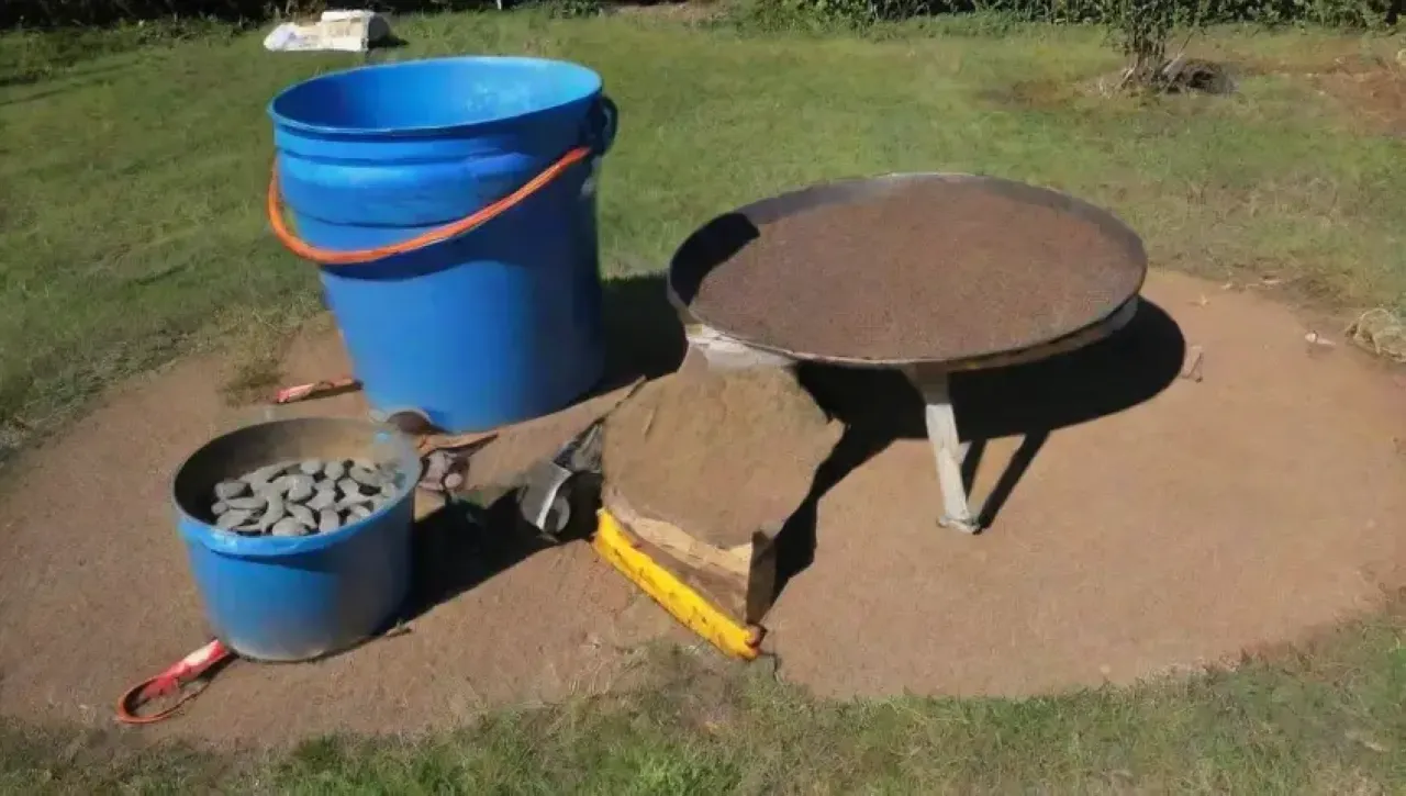 Un día soleado en un campo verde con trabajadores construyendo un tanque de agua